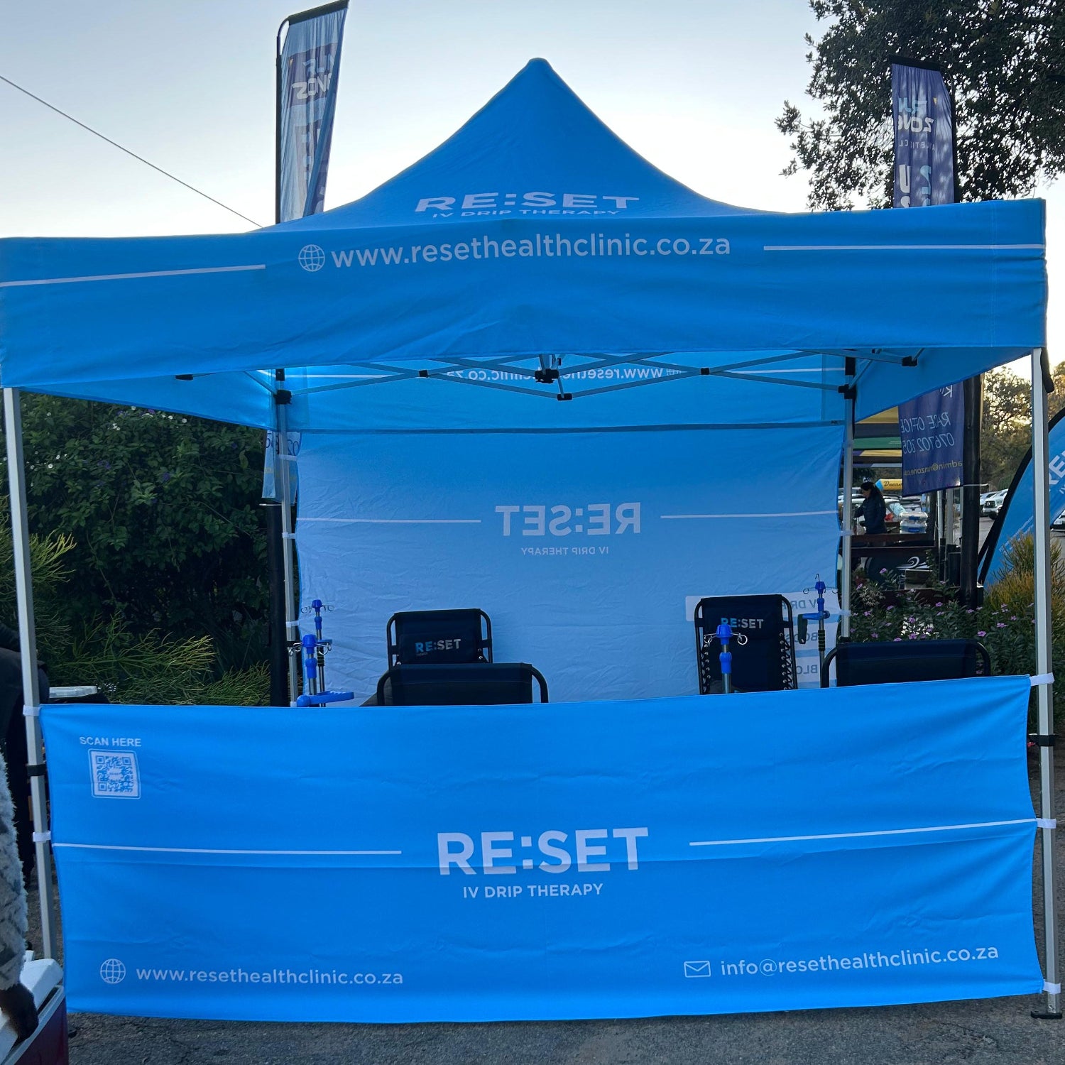 Blue tent with 'RE:SET' branding and text on a clear day.